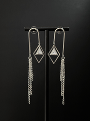 DIPHDA Cosmic Waterfall Earrings with cubic zirconia triangle charms and gold chain fringe, displayed against a celestial backdrop