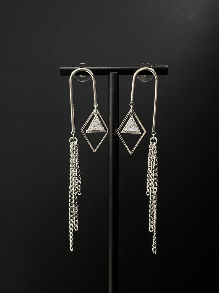 DIPHDA Cosmic Waterfall Earrings with cubic zirconia triangle charms and gold chain fringe, displayed against a celestial backdrop